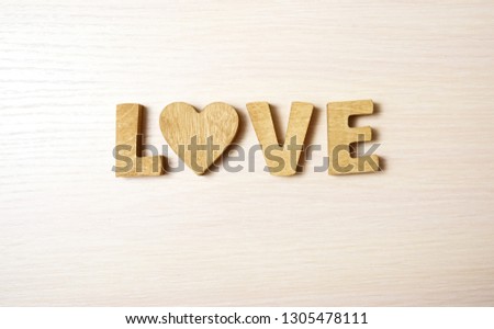 love word made from wooden letters and wood heart. wooden background. 