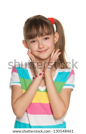 Portrait of a shy girl in a striped blouse makes a hands gesture