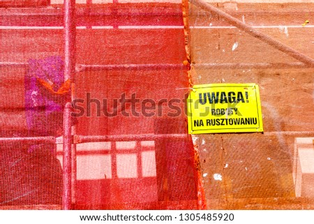 Red net protective cover on construstion site with yellow warning sign in polish. Constructing objects and detail concept.