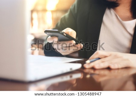 The picture of officer working action on wooden table, consist of laptop, paper and pencil. Selective focus