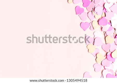 Beautiful delicate paper background for copy space, greeting card design, little hearts on a pastel pink background, top view