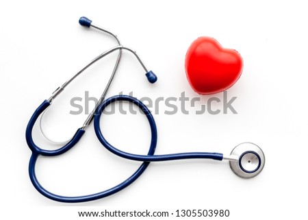 Heart health, health care concept. Stethoscope near rubber heart on white background top view