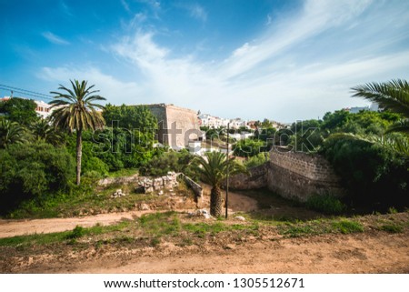 beautiful colorful image of ciutadella de menorca, summer day, nature in connection with a city, old castle building in background