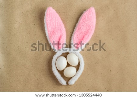 Top view of bunny ears easter holiday accessory and white egg on rustic background with copy space