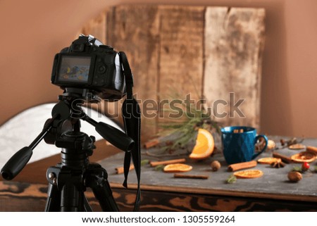 Professional photo camera near composition on table in studio