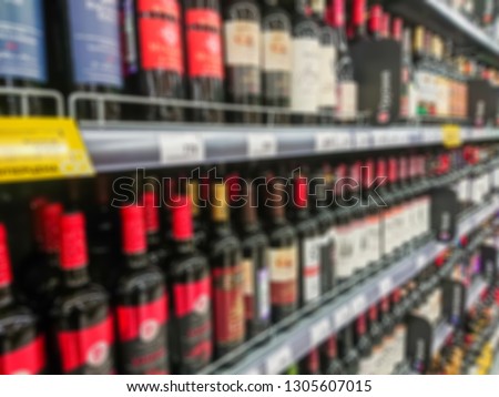 Abstract blurred image. Defocused lens. Wine, cognac and other alcoholic beverages on the shelves in the supermarket.
