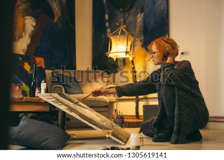 woman artist painting in her atelier