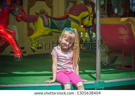 Girl sitting on the carousel