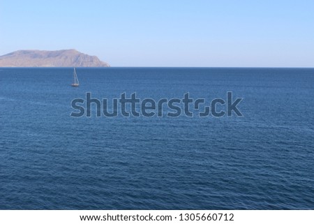 Superb seascape overlooking the rocky Black Sea coast in the Crimea. On the water surface floats luxury yacht. Bright and positive summer at sea