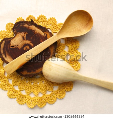 Wooden spoons on isolated background, crocheted yellow lace, napkin. The idea of healthy food, handmade, homemade food, needlework
