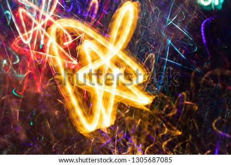 Bright yellow light on multicolored glowing backdrop. 
