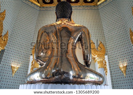 Golden buda statue in a wat temple in Bangkok. Picture taken from the back side of the statue.