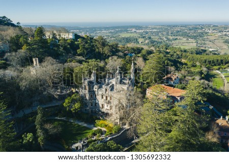 Aerial; drone view of Quinta da Regaleira palace on the Sintra hilltop; World Heritage Site by UNESCO; famous monument, touristic attraction of Portugal; sunny day in the national park