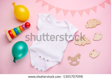 Layout Flat Lay a white baby bodysuit on a pink background, for girls with gifts. Layout for the design and placement of logos, advertising