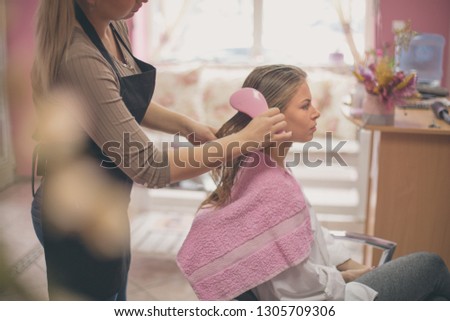 Let your hair be straight and beautiful. Woman at the hairdresser. Hairdresser brushing hair. Close up.