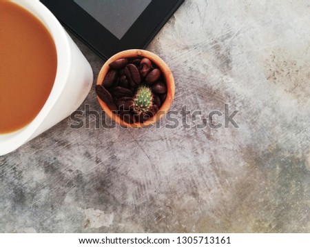 Top view Cactus,tablet, coffee cup and copy space for writing messages on vintage gray cement background.