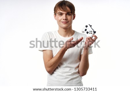 Cute gamer guy holds the controller hands from the gaming console on a light background
