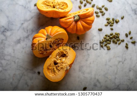 Sliced pumpkin with seeds on a marble table