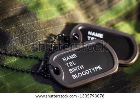 Soldier tag or dog tag laid on military jacket and morning sunlight. Concept of protecting for a new day.