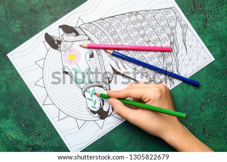 Woman coloring anti stress picture with pencil, top view