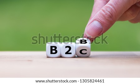 Business to Business or Busness to Consumer? Hand turns a dice and changes the expression "B2B" to "B2C" (or vice versa) Royalty-Free Stock Photo #1305824461