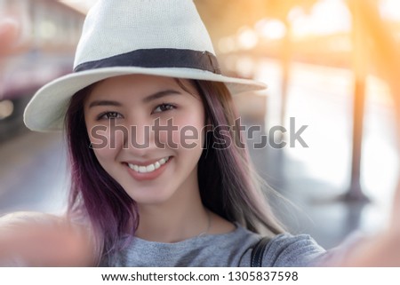 Attractive beautiful young woman selfie or taking photo by herself for keeping good impression or good memory when beautiful asian woman traveling to foreign country by alone. happiness, smiley face