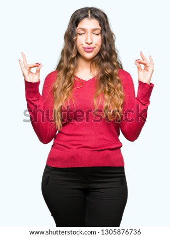 Young beautiful woman wearing red sweater relax and smiling with eyes closed doing meditation gesture with fingers. Yoga concept.