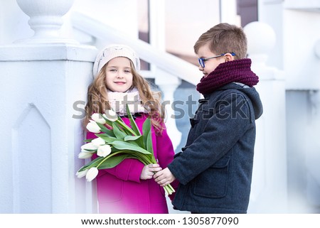 Boy and girl on a date in a beautiful place with a bouquet of flowers.