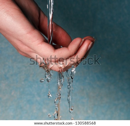 human hands with water splashing on them