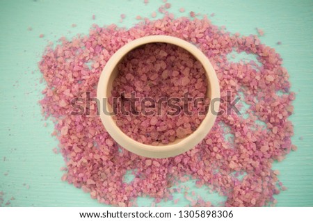 Bright picture with pink sea salt in a pot. Top view. Close-up. Natural mineral for relaxation. Cosmetic therapy. 