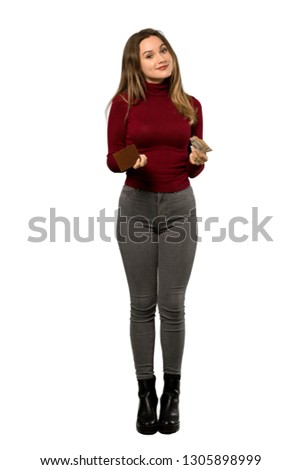 A full-length shot of a Teenager girl with turtleneck holding a wallet over isolated white background