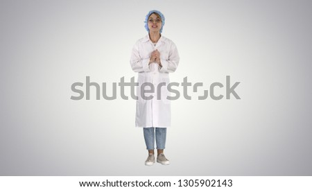 Smiling cute medical doctor woman talking to camera on gradient background.