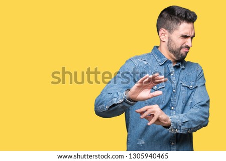 Young handsome man over isolated background disgusted expression, displeased and fearful doing disgust face because aversion reaction. With hands raised. Annoying concept. Royalty-Free Stock Photo #1305940465