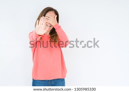 Beautiful middle age woman over isolated background covering eyes with hands and doing stop gesture with sad and fear expression. Embarrassed and negative concept.