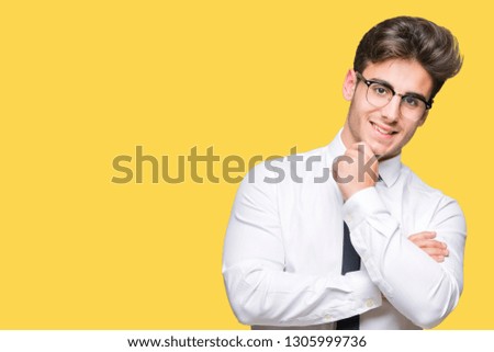 Young business man wearing glasses over isolated background looking confident at the camera with smile with crossed arms and hand raised on chin. Thinking positive.
