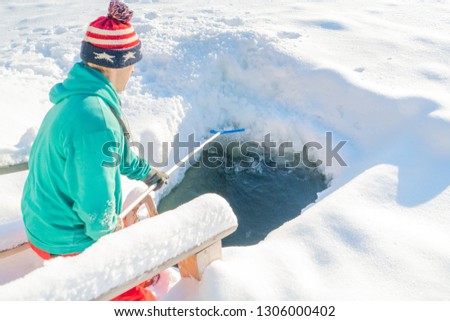 Man cleans in winter, a hole in the ice