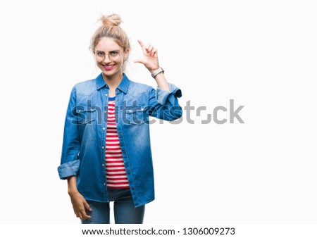 Young beautiful blonde woman wearing glasses over isolated background smiling and confident gesturing with hand doing size sign with fingers while looking and the camera. Measure concept.