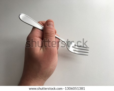 Holding a fork in hand white background Caucasian eating utensil close up top down view angle silverware man