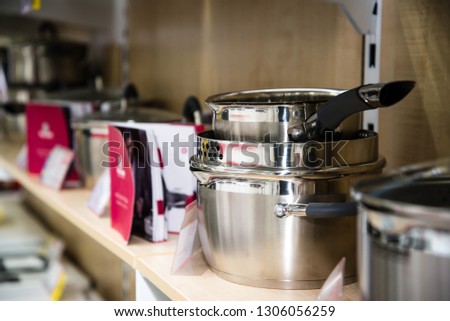Stainless steel kitchenware set on shelves, shallow depth of field image