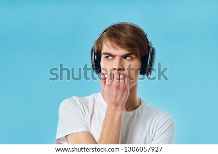 nice guy in headphones in white t-shirt on blue isolated background