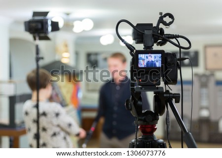 Video of the interview. Television equipment, camcorder with LCD screen, lighting equipment.