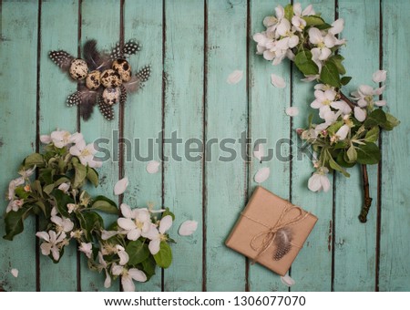 Easter eggs decoration on rustic wooden background. Quail  eggs gift box and spring apple blossom on a old wooden background. Vintage style picture. 