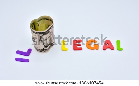 COLORFUL WORD ILLEGAL SLIT UP BY A FIVE DOLAR BANKNOTE IN TWO, IL AND LEGAL MEANING THAT THINGS ARE LEGAL OR ILLEGAL DEPENDING ON THE MONEY. HORIZONTAL PHOTO. 
