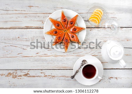 Azerbaijan national pastry pakhlava on white plate and a cup of tea and lemon slices on white wooden table ,top view,spring new year celebration Novruz,copy space 