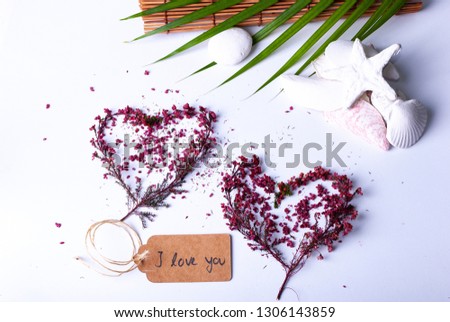 Tow hearts made of colorful branches and a label saying "Valentinstag" on white background with natural fresh decoration