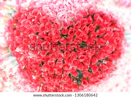 bouquets of artificial red roses for valentines in heart- shaped pattern with blurry vignettes