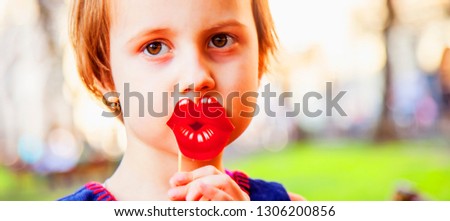 Healthy mental and emotional development concept. Funny cutel little child girl playing with fake lips.