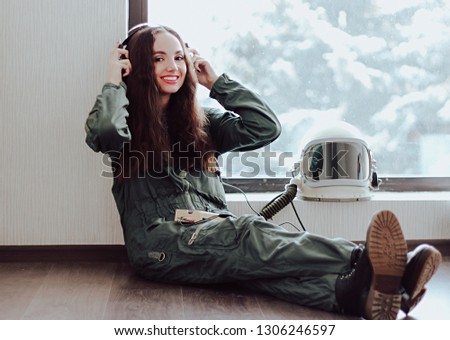 Blurred Background for Wallpaper. Happy girl smiling. Cute girl in a space suit listening to music. Astronaut girl in space helmet. Young girl in an astronaut suit. Space helmet. Nice and kind smile. 