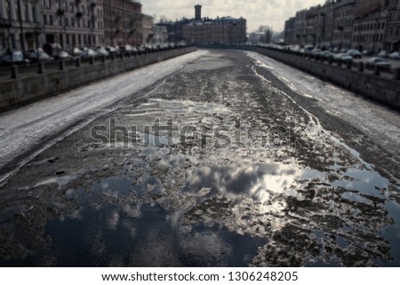 Springtime, sign of spring. Ice drift (debacle) on the channel in the Northern town of St. Petersburg, Russia. Cars are blurred.