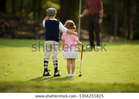Siblings with their arms around each other on golf course